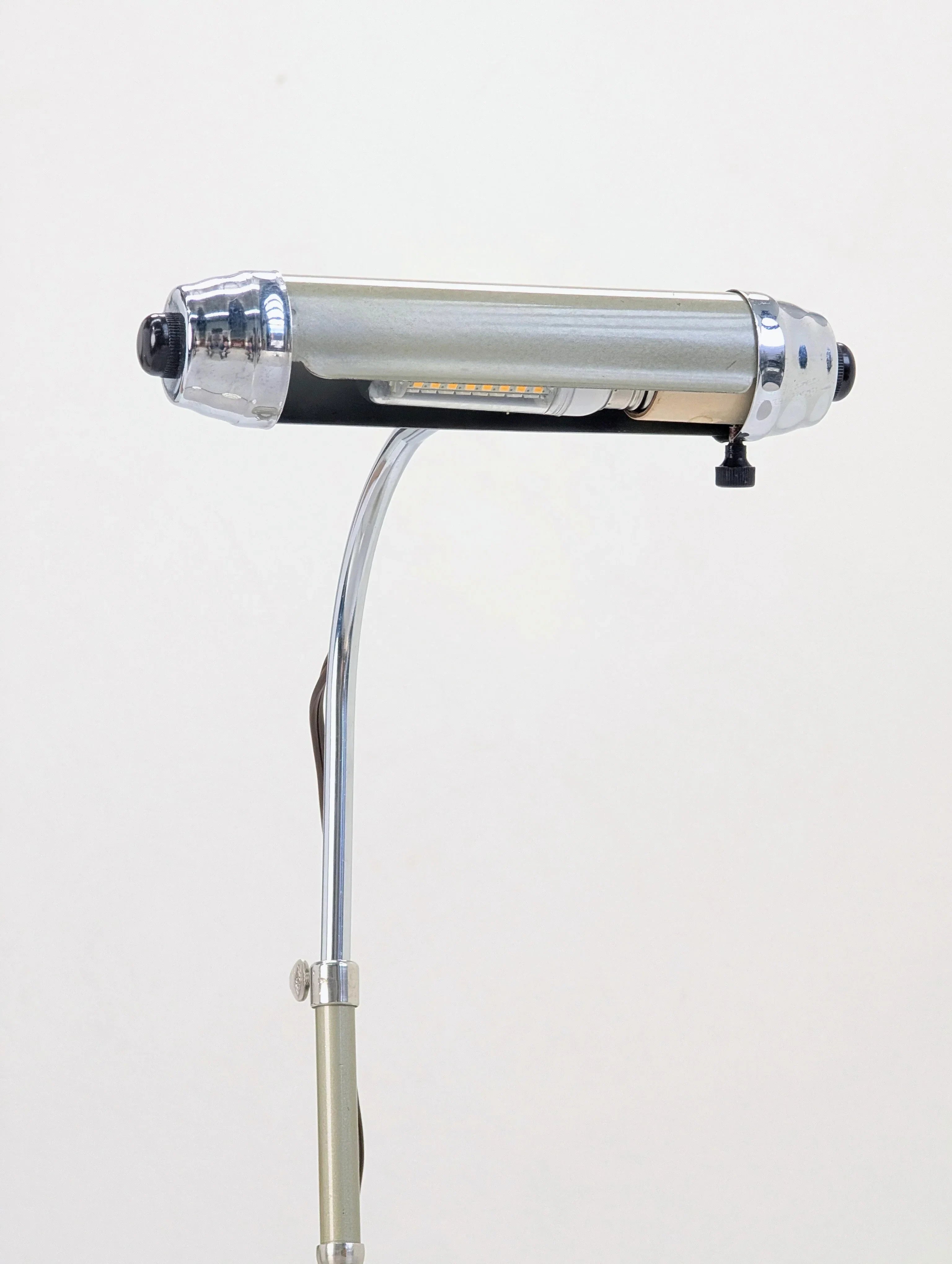 vintage chrome and metal desk lamp with tubular shade on a white background