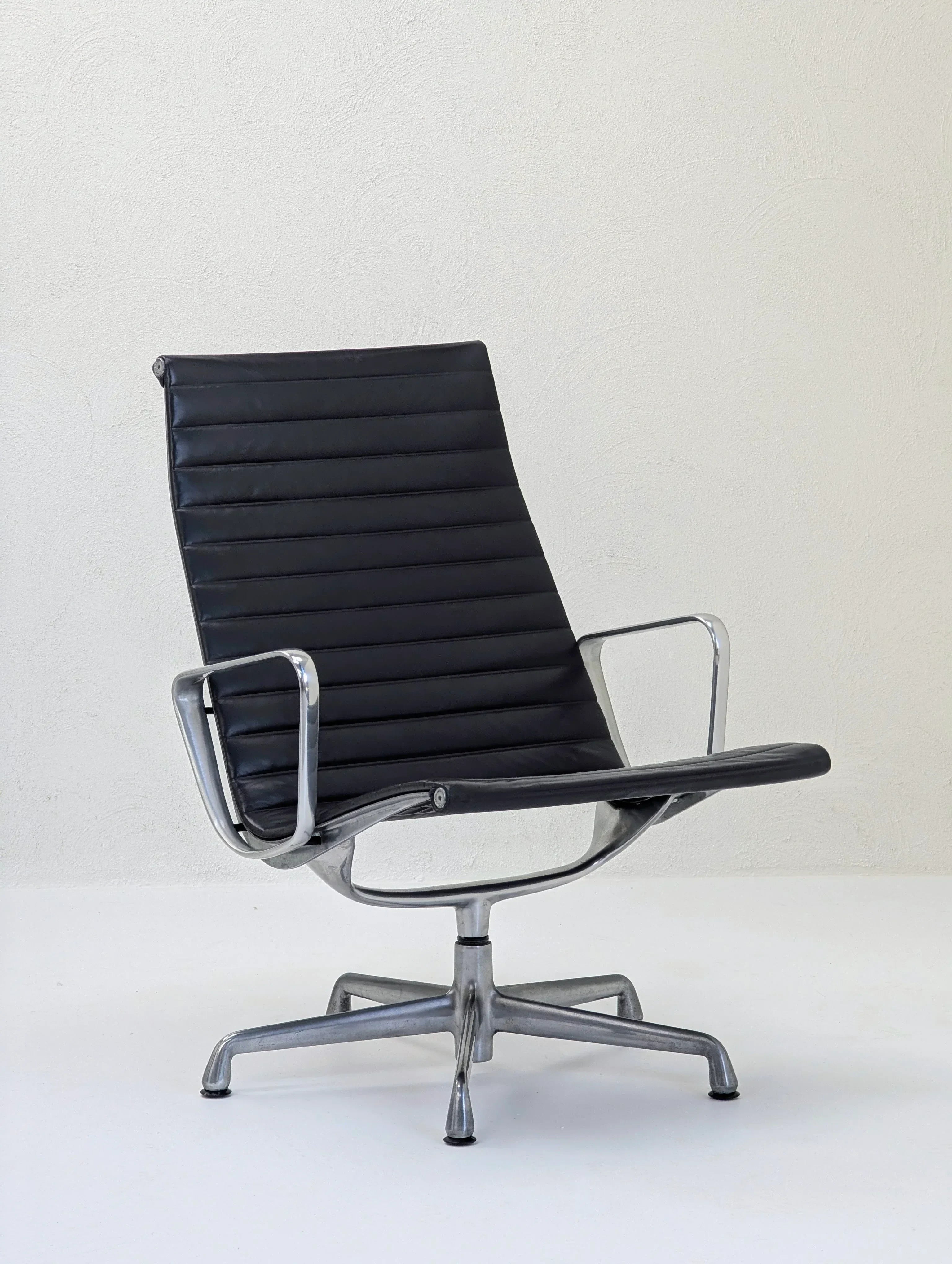 Black leather swivel office chair with metal frame on white background
