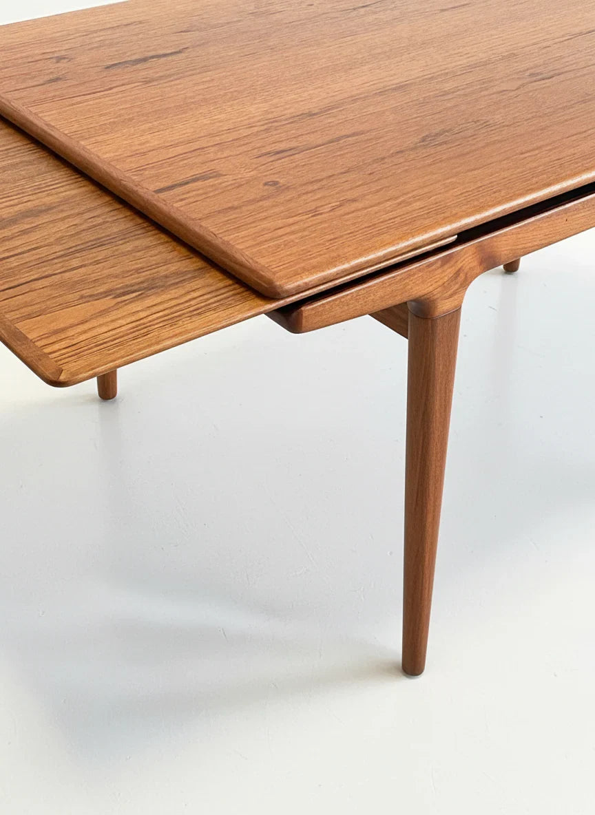 Mid-century modern teak extendable wooden dining table with tapered legs on white floor