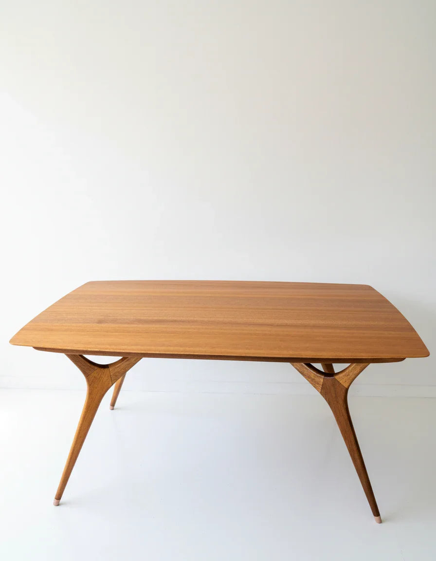 Mid-century modern wooden dining table with tapered legs and smooth rectangular top