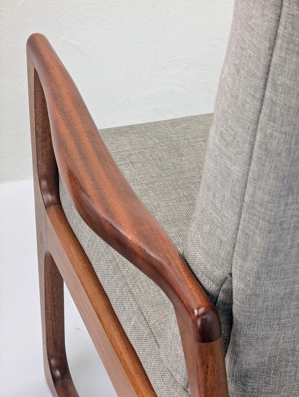 Mid-century modern chair with walnut wood armrest and light grey fabric upholstery