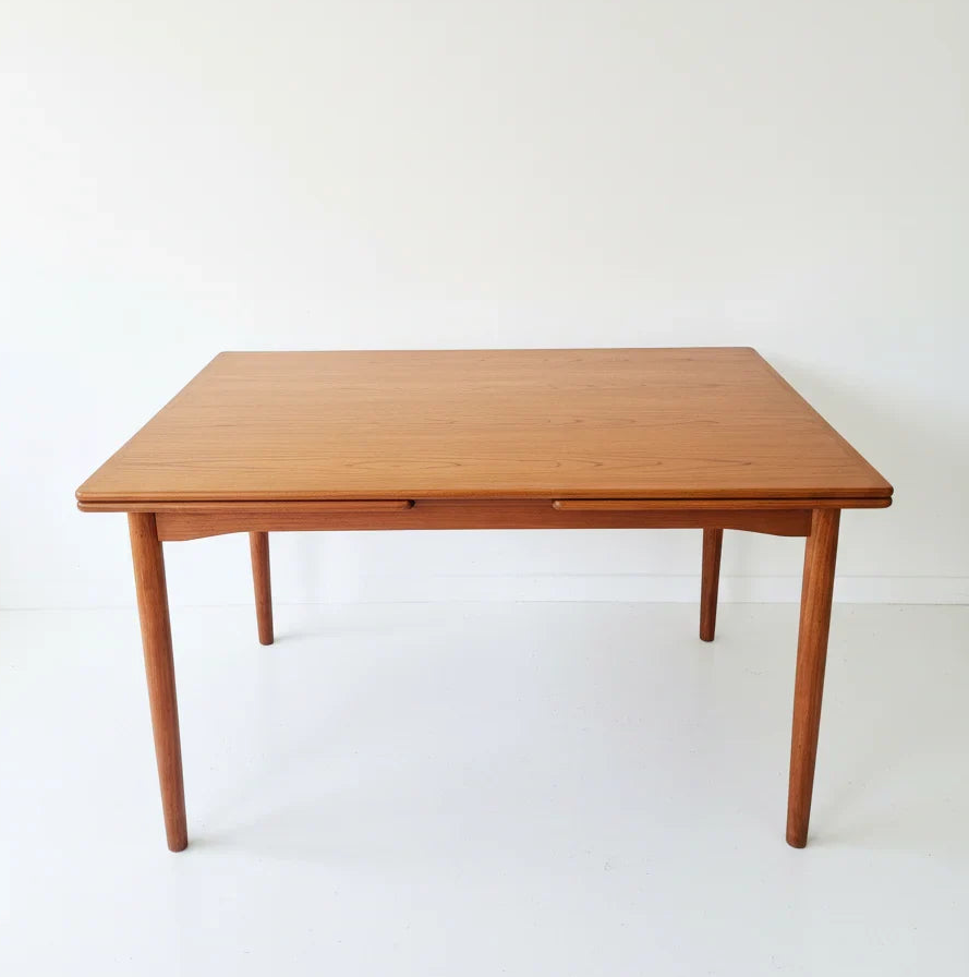 Minimalist mid-century modern wooden dining table with tapered legs on white background
