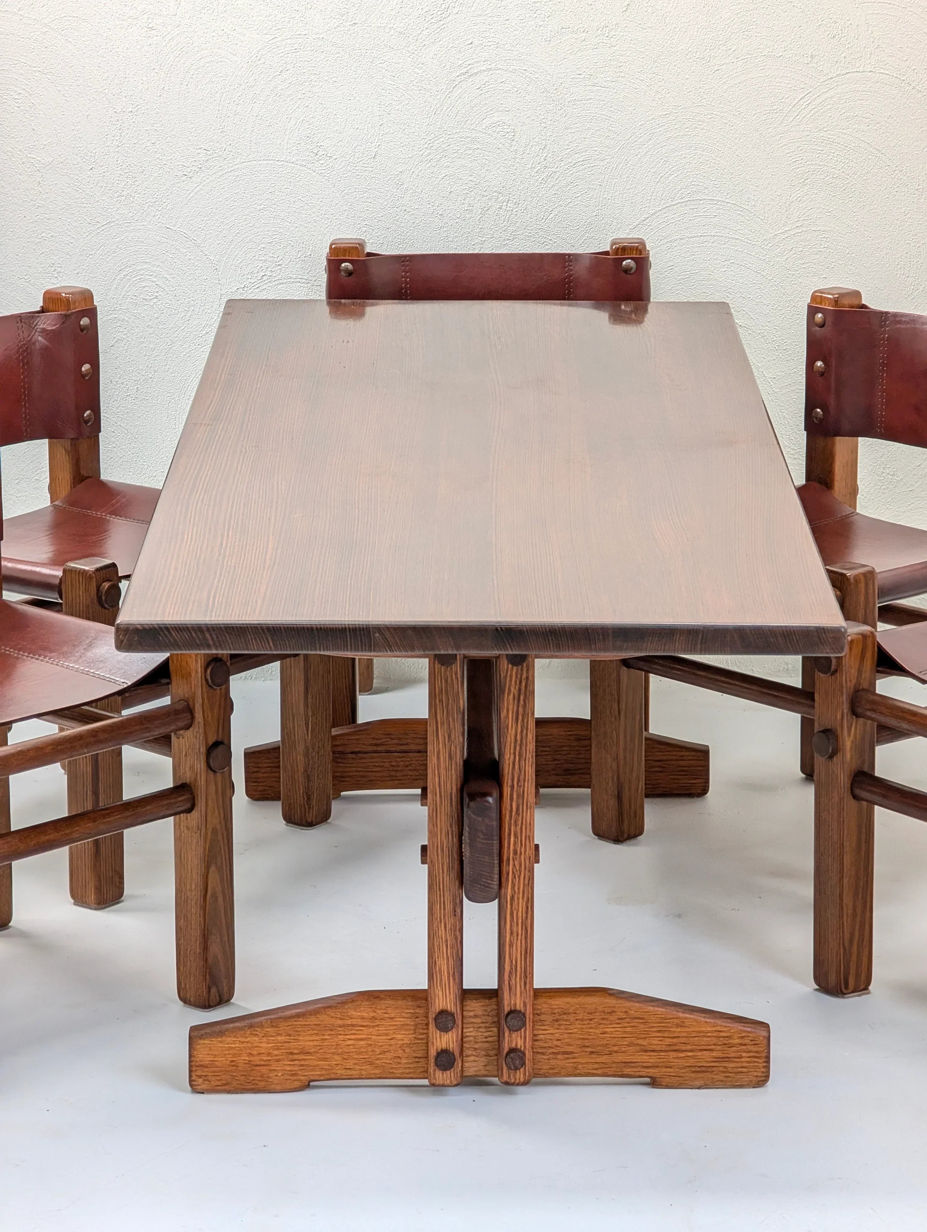 Mid-century modern wood dining table with four brown leather and wood chairs