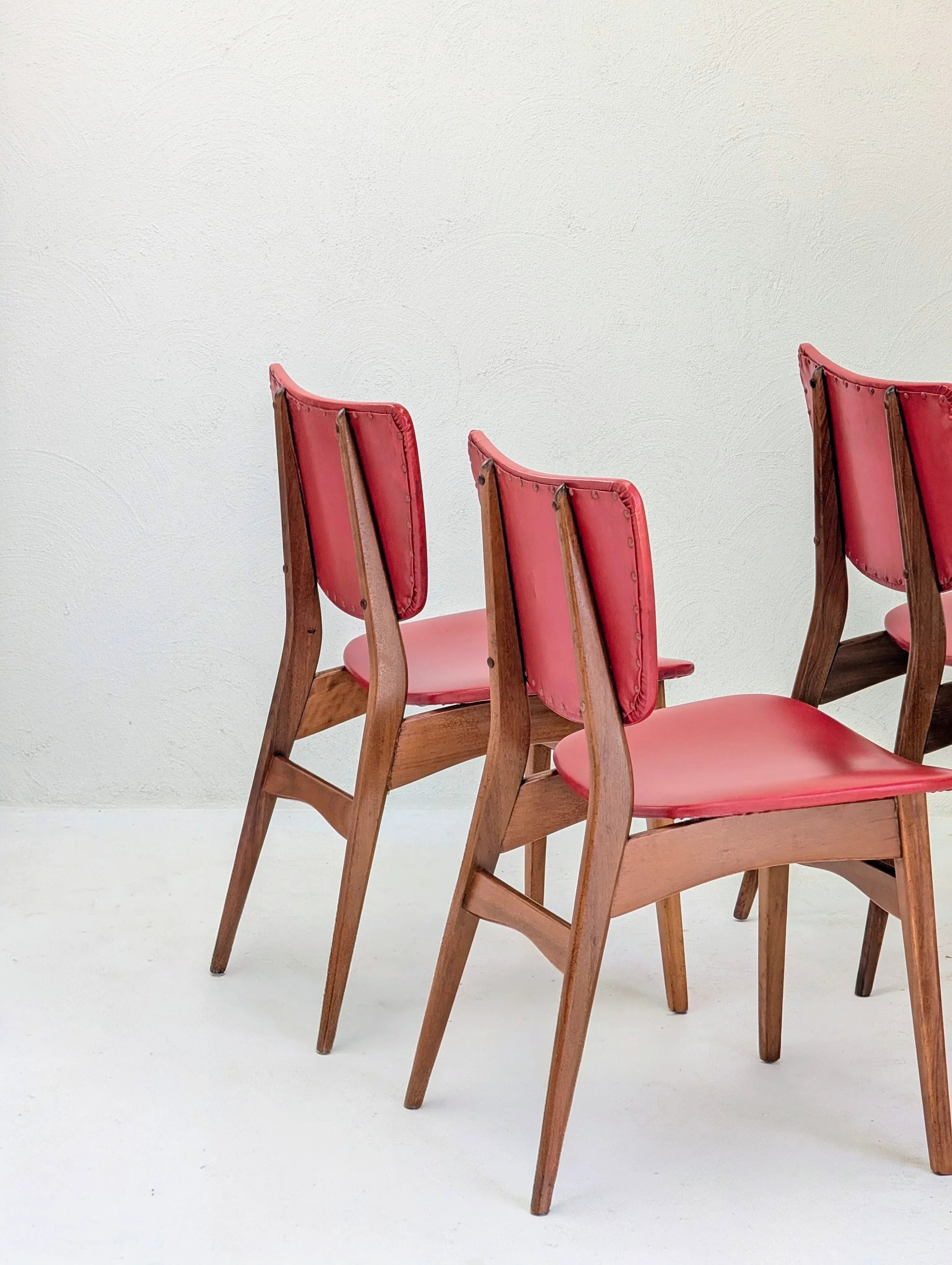 Mid-century modern wooden chairs with red leather seats in a minimalist setting