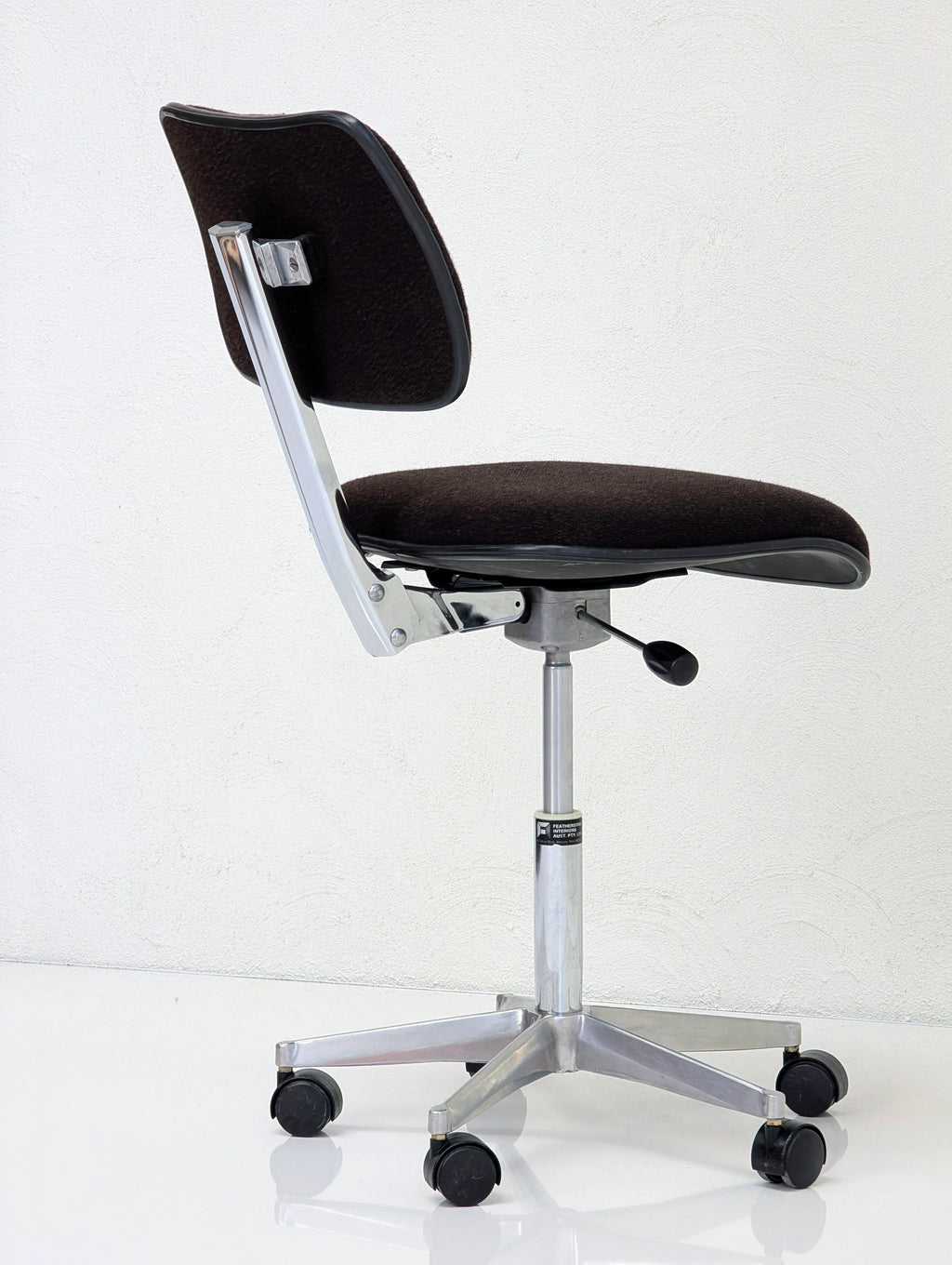 Black ergonomic office chair with chrome base and wheels on white background