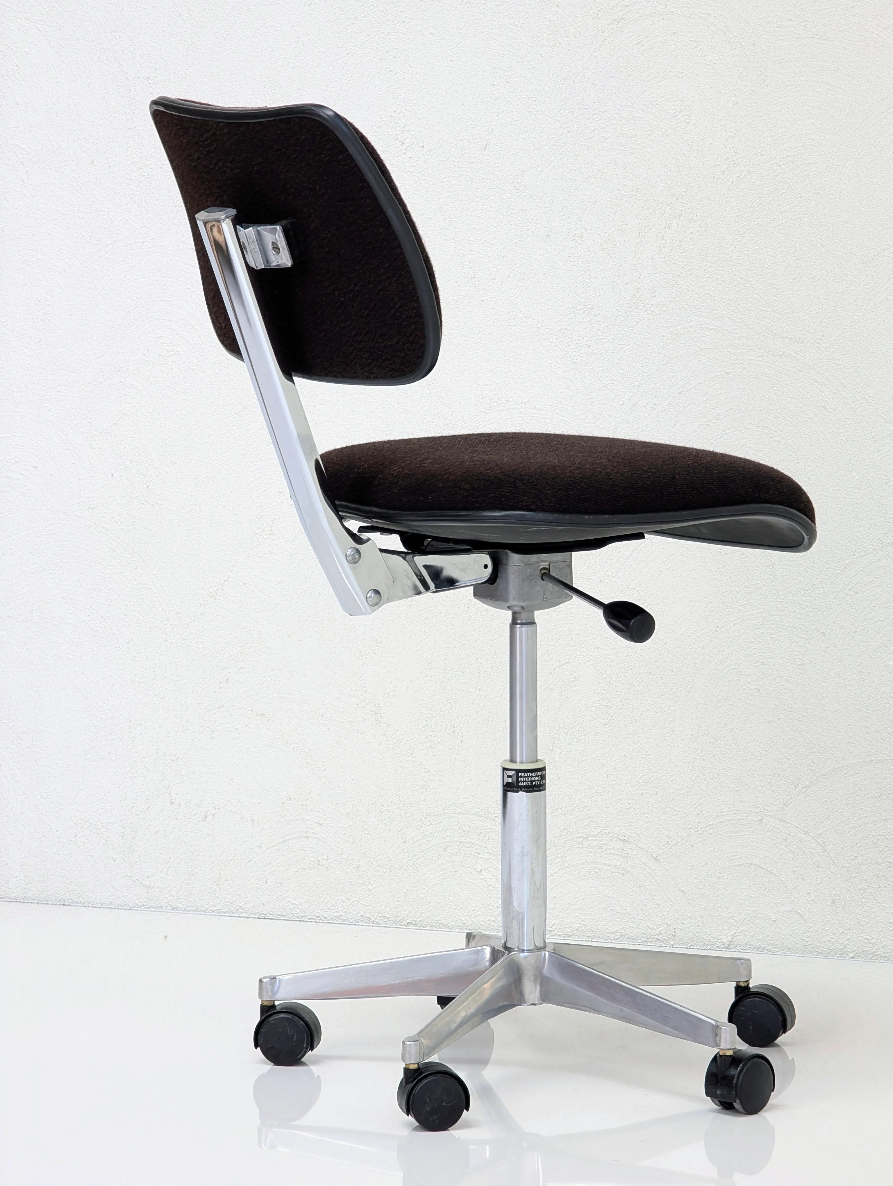 Black ergonomic office chair with chrome base and wheels on white background