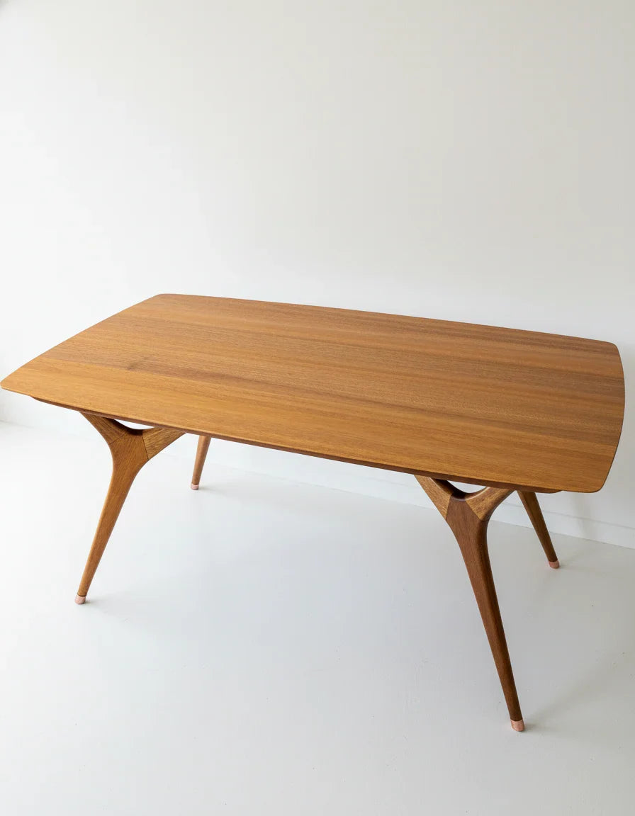 Minimalist mid-century modern wooden dining table with tapered legs on white background
