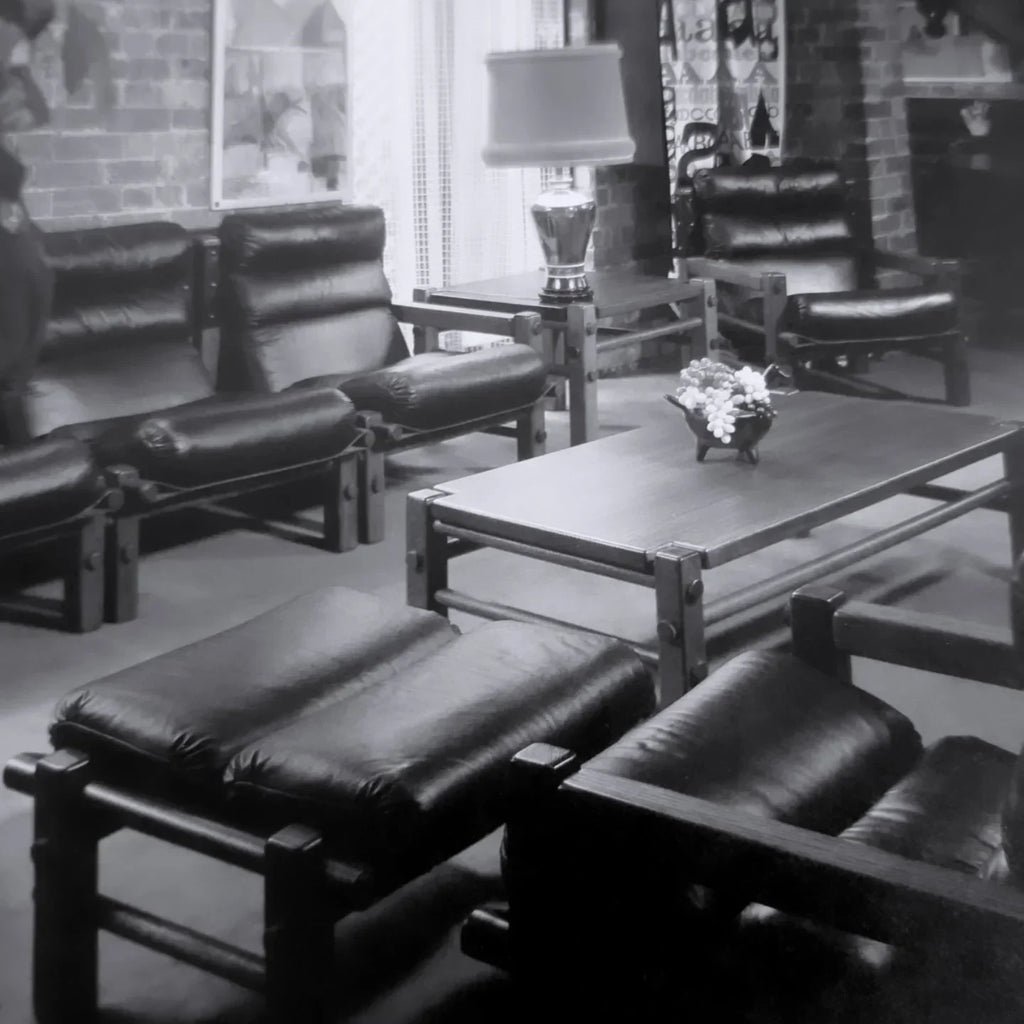 Vintage black and white photo of leather lounge chairs and coffee table in retro living room