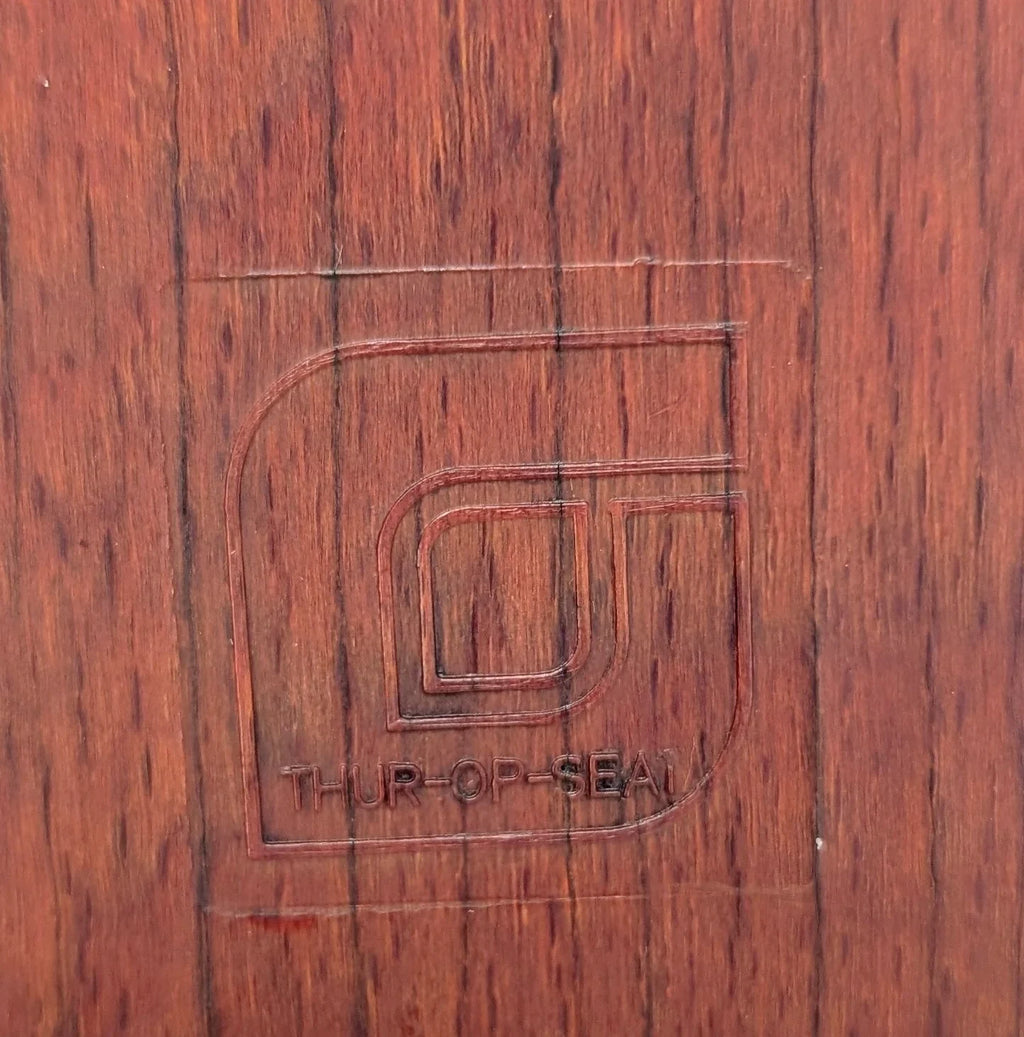Embossed THUR-OP-SEAL logo on reddish-brown wood grain surface