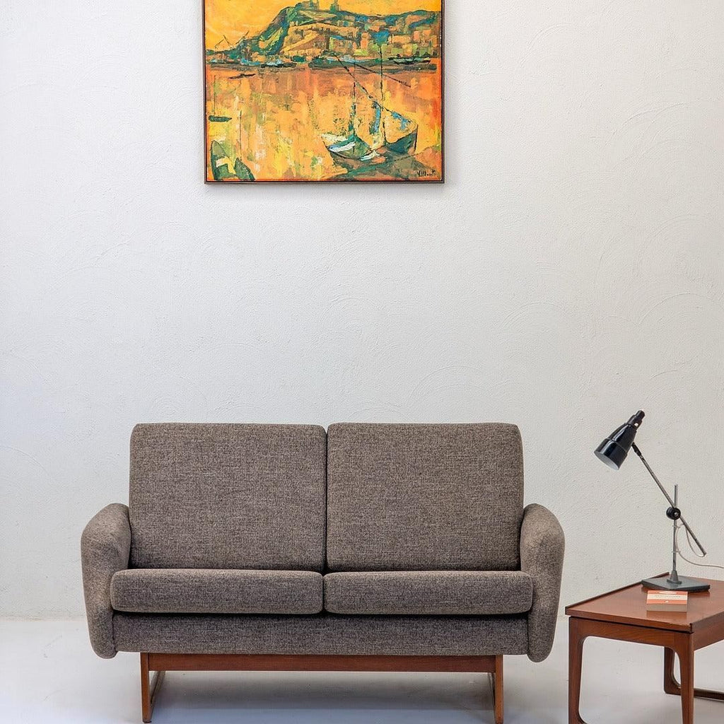 Mid-century modern grey sofa, side table with lamp, and abstract yellow painting in living room