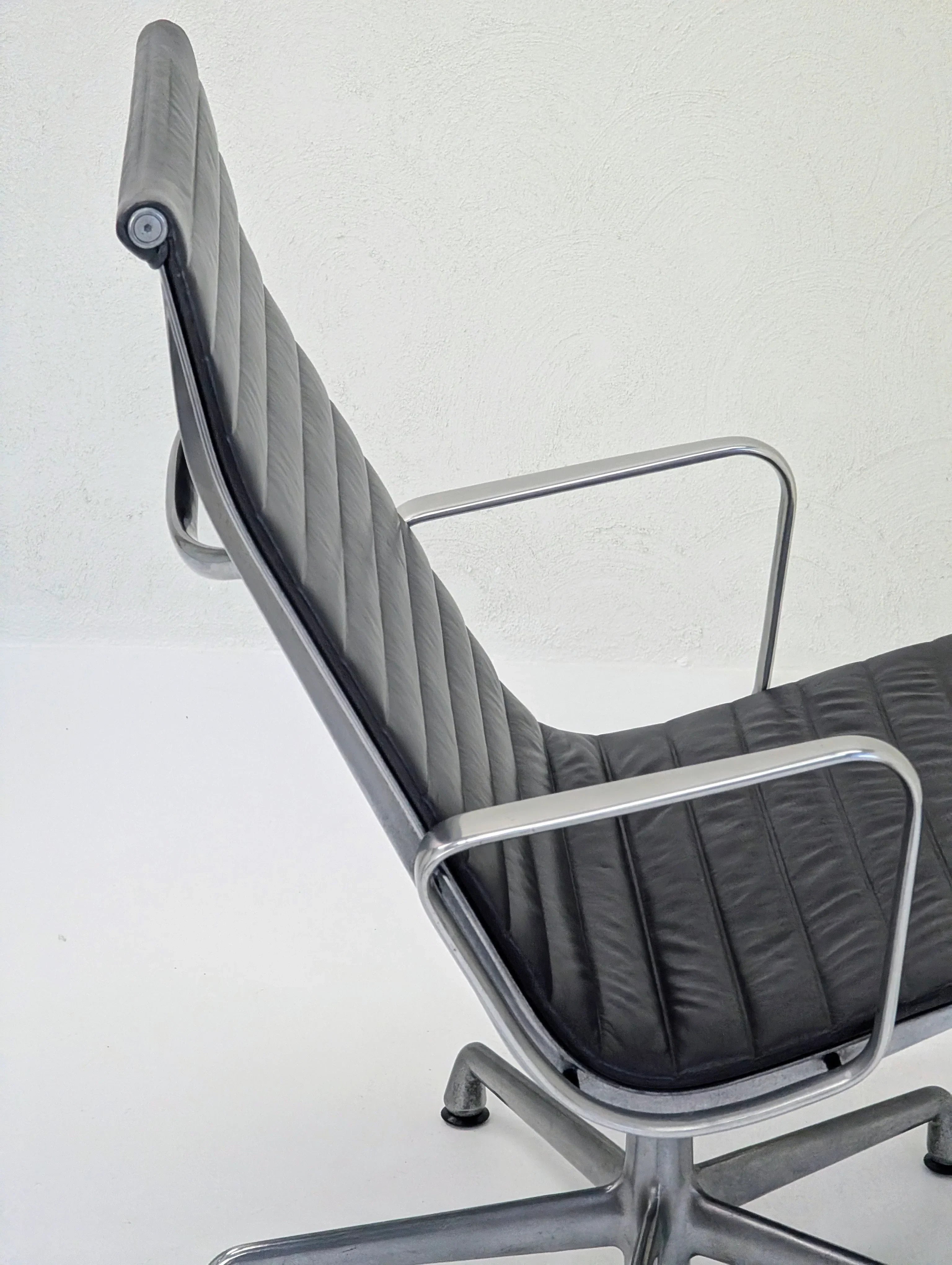 Modern black leather office chair with metal frame on white background