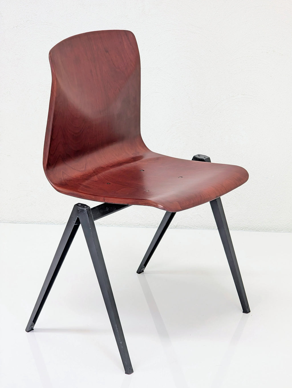 Modern wooden chair with dark metal legs on white background