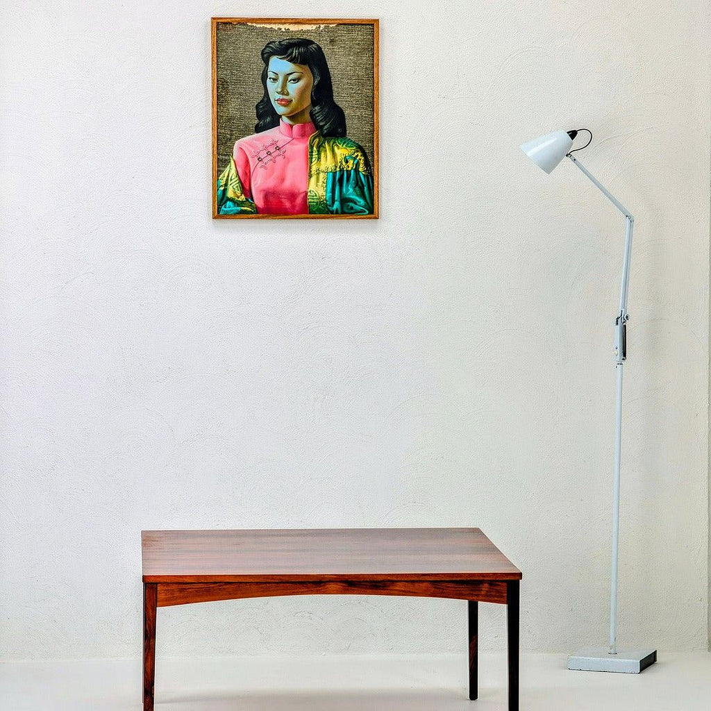 Minimalist room with portrait painting, wooden table, and white floor lamp against white wall