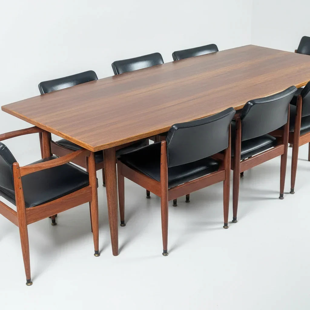 Mid century modern wood dining table with eight black leather chairs in minimalist room