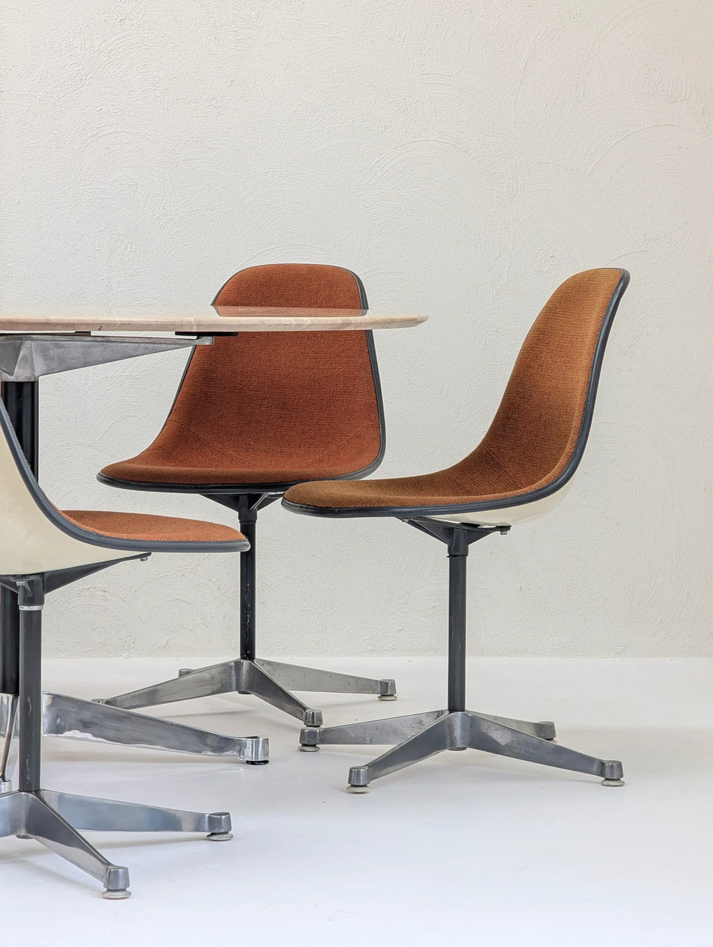 Mid-century modern swivel office chairs with brown upholstery by a light wood table