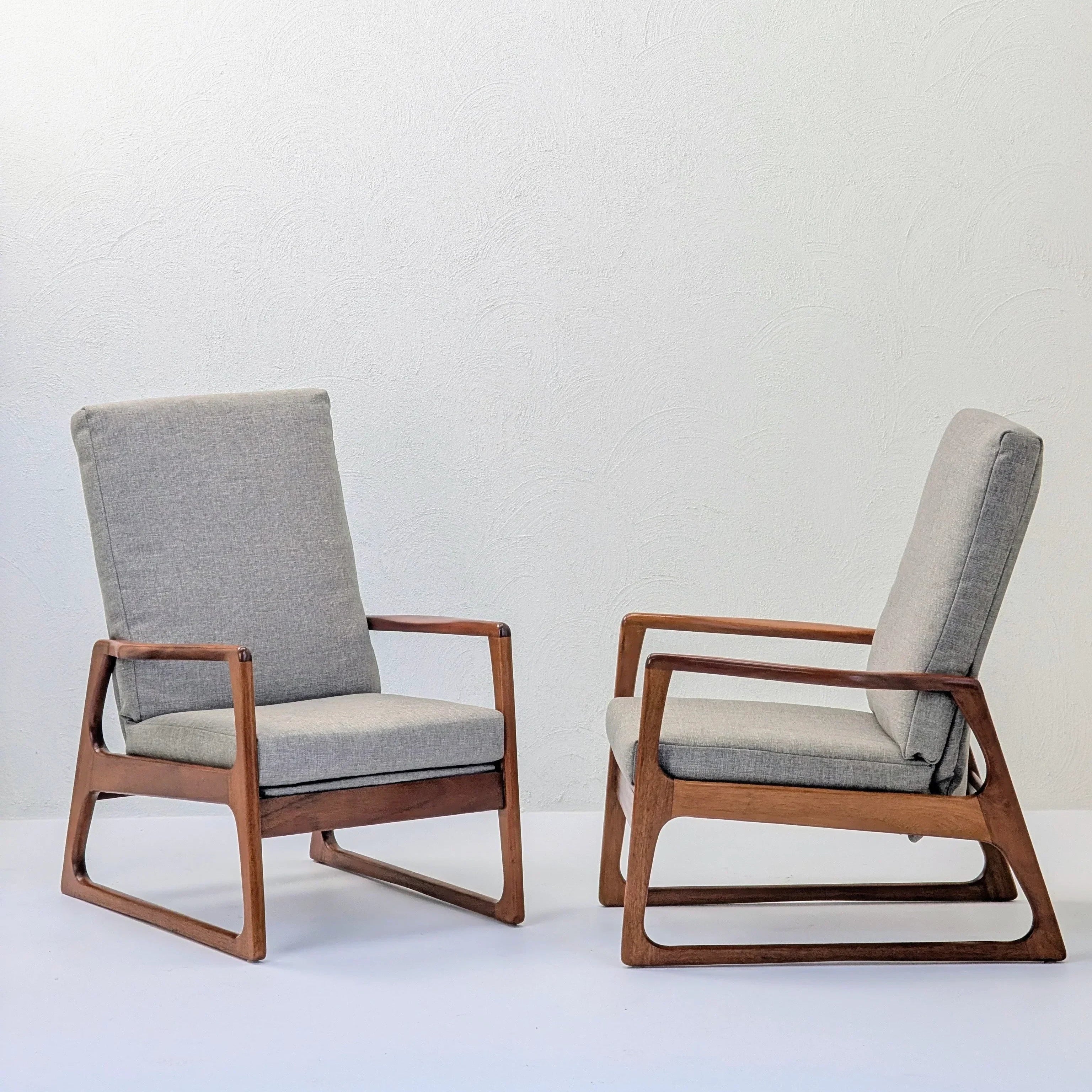Pair of mid century modern accent chairs with wooden frames and gray cushions on white floor
