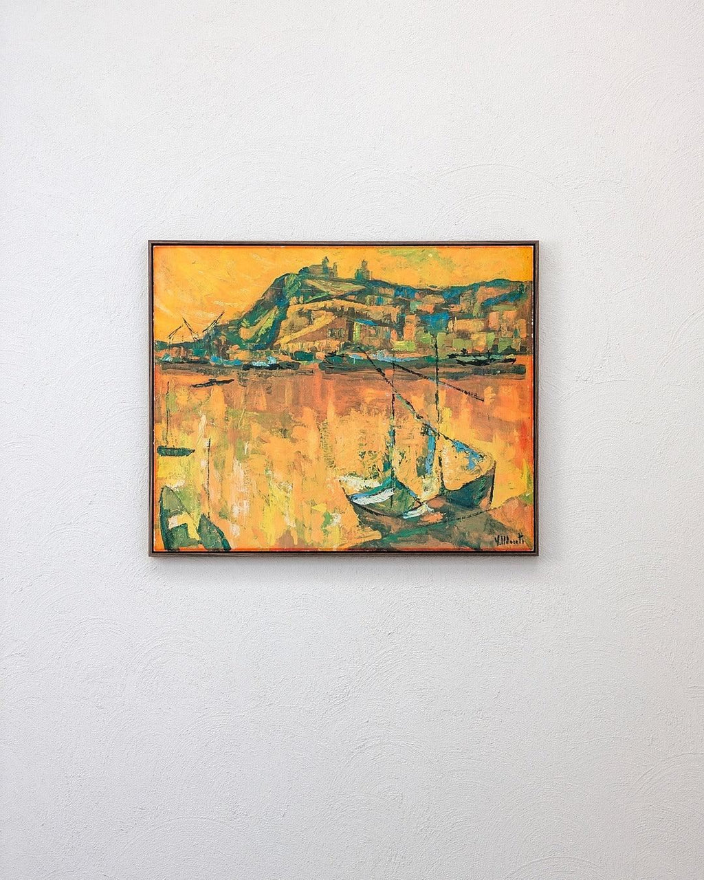 Framed abstract landscape painting with boats and hills on a white textured wall