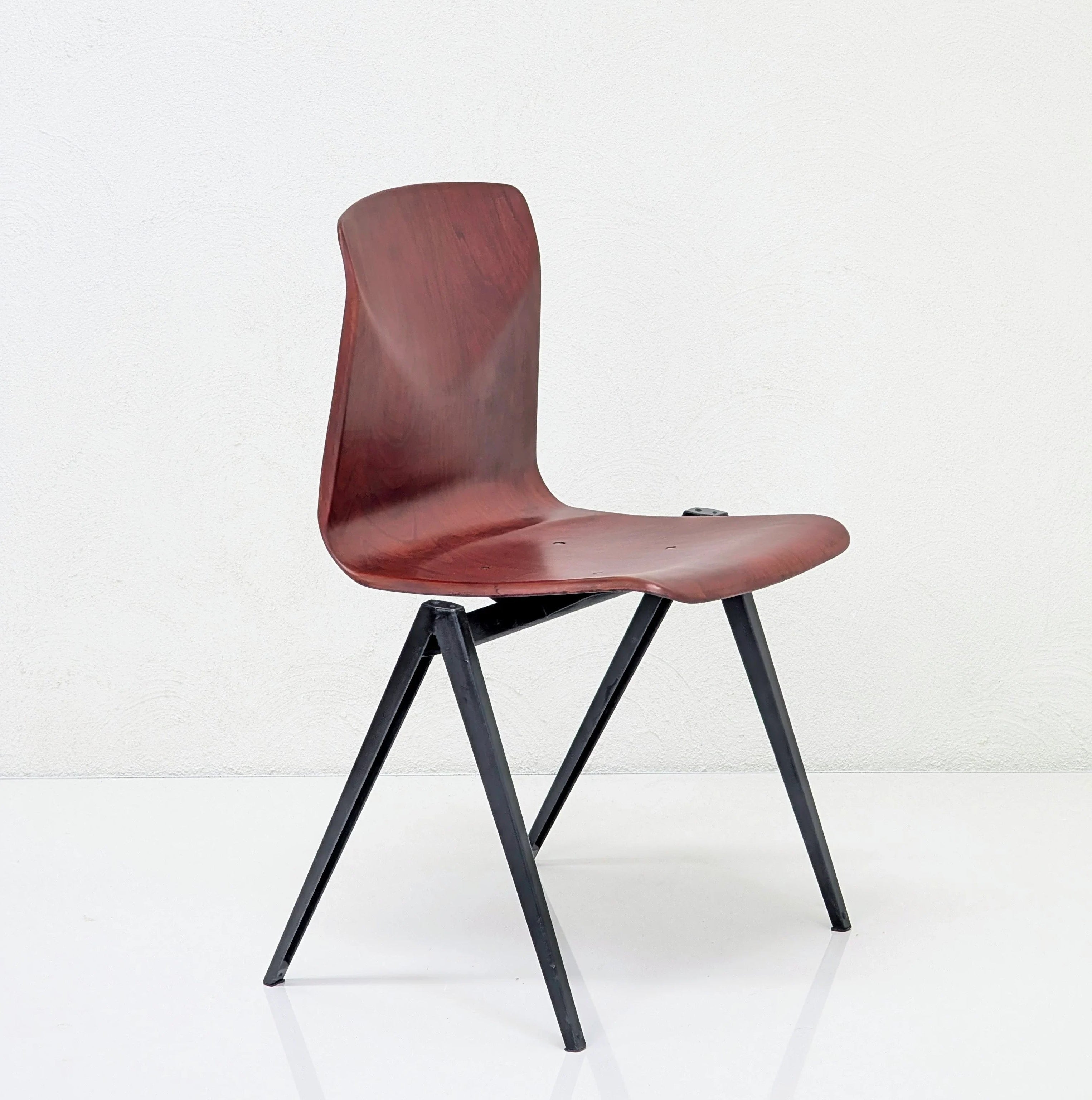 Modern wooden chair with sleek curved seat and backrest on black metal legs
