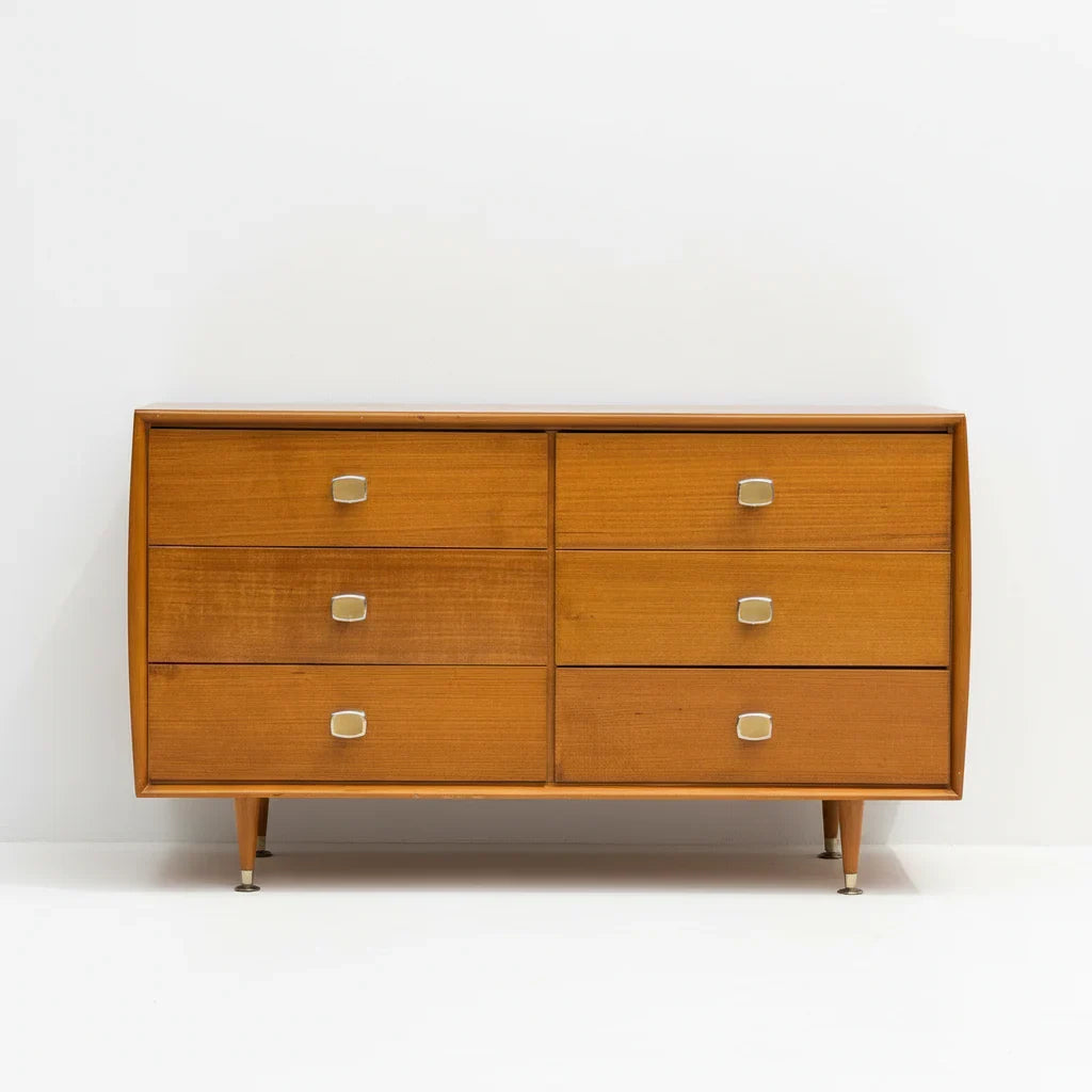 Mid-century modern wooden dresser with six drawers and metal handles on white background
