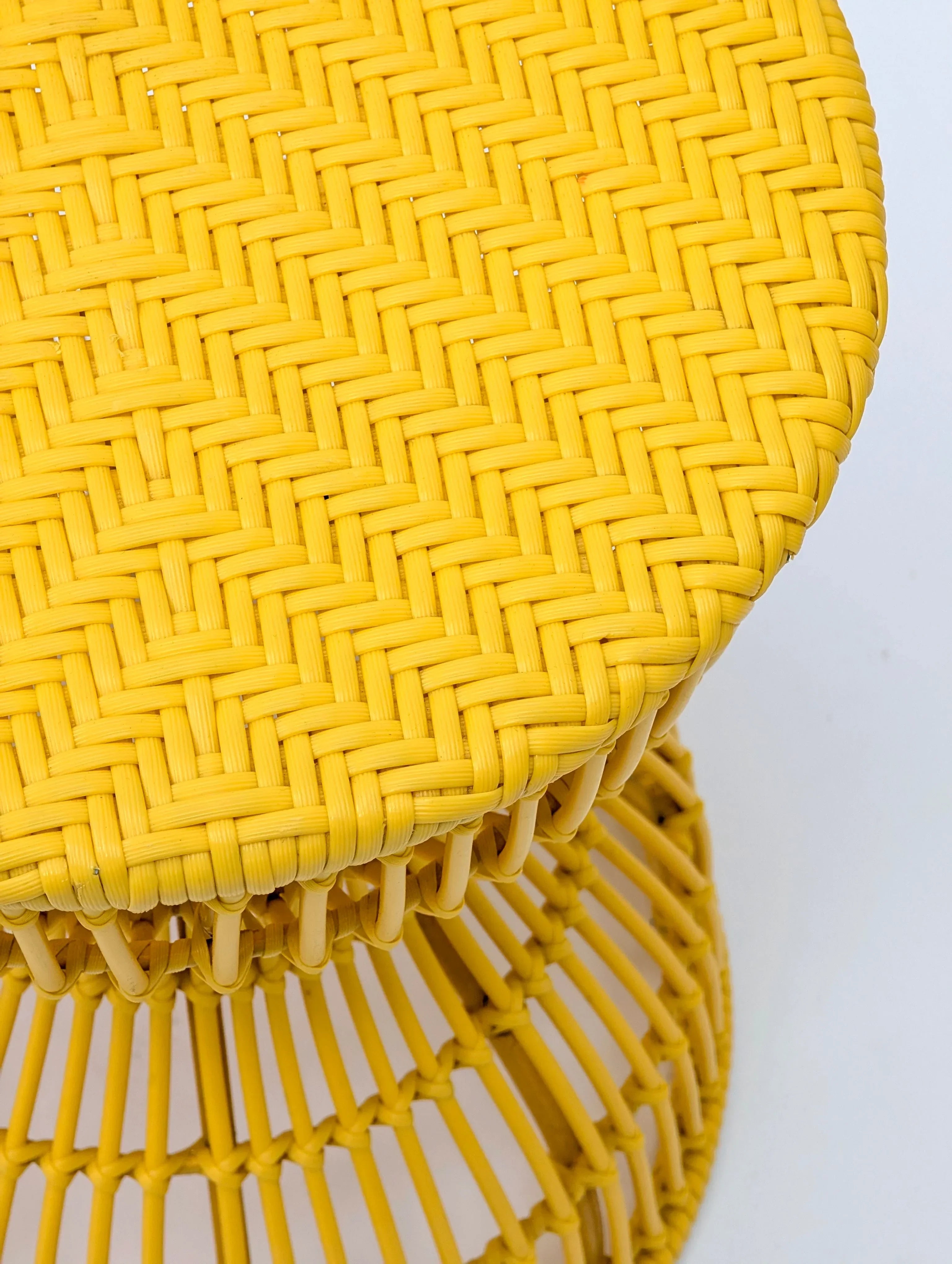 Yellow woven rattan stool with round top on white background