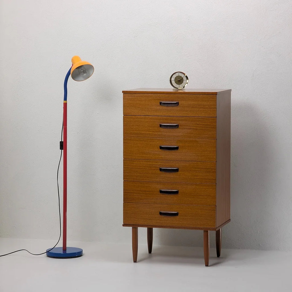 Mid-century modern wooden dresser with five drawers, colorful floor lamp, and round clock