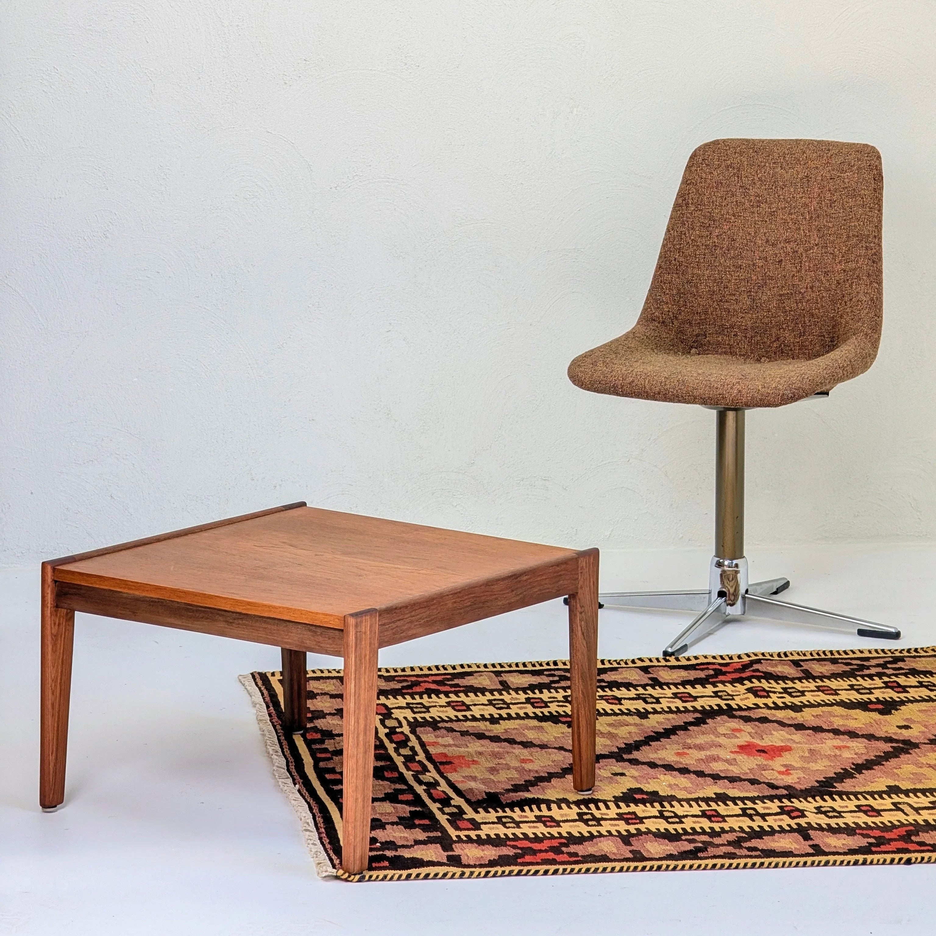 Mid-century modern brown fabric swivel chair and wooden square coffee table on patterned rug