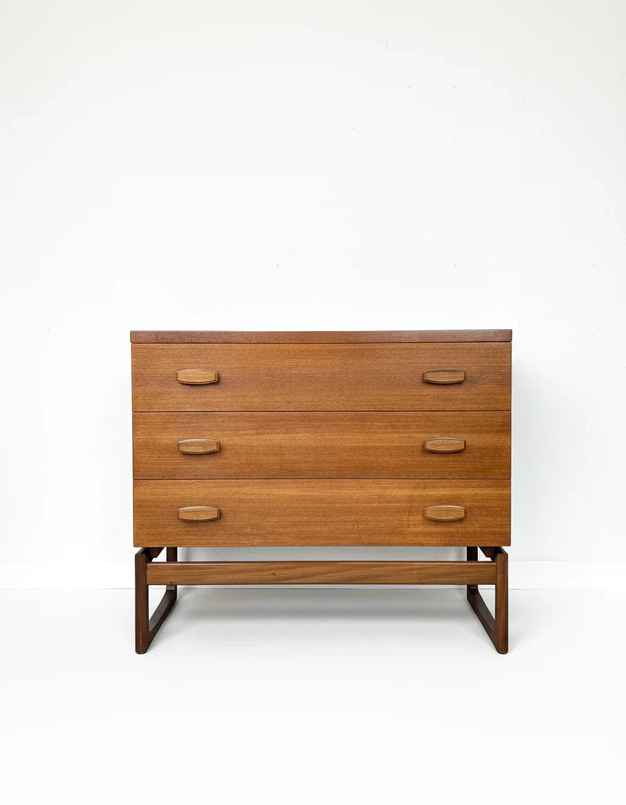 Mid-century modern wooden dresser with three drawers and sculpted handles on minimalist frame