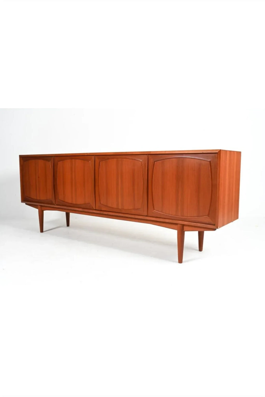 Mid-century modern teak sideboard with four paneled doors and tapered legs on white background
