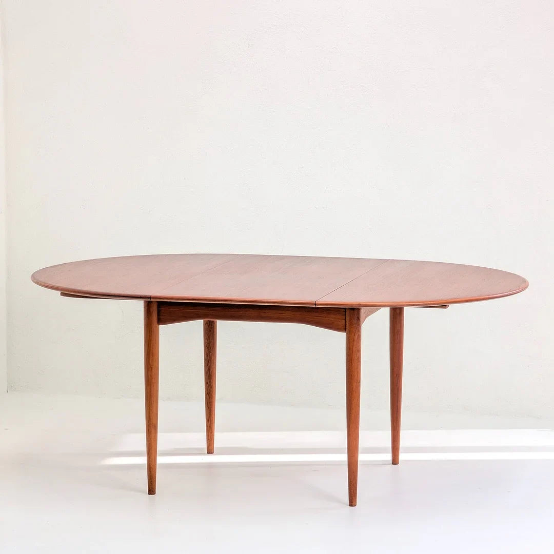 Mid-century modern oval teak wood dining table against a plain white background