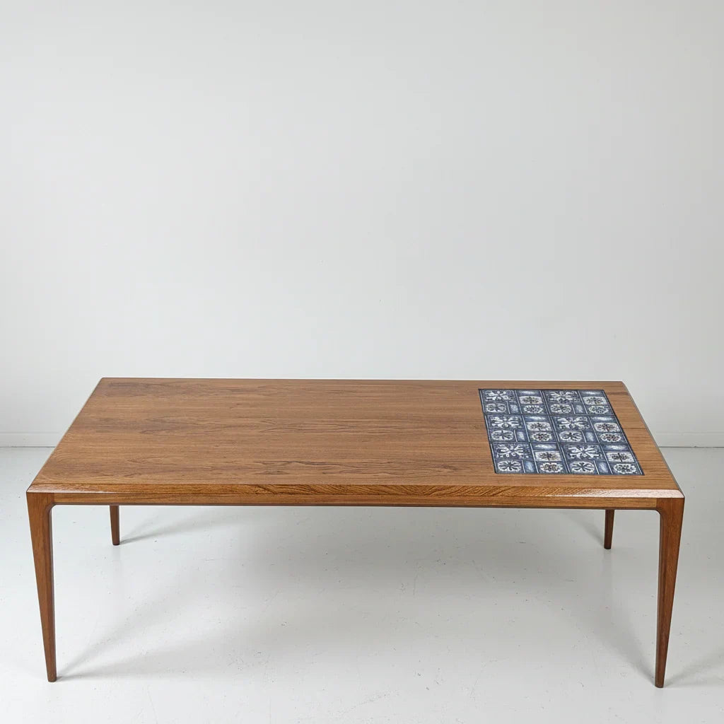 Mid-century teak coffee table with blue ceramic tile inlay on white background