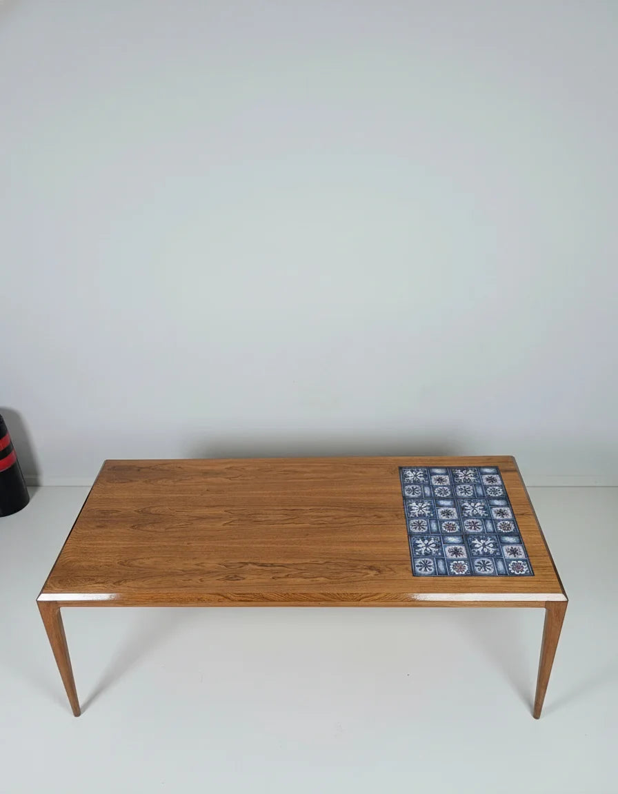 Mid-century modern wood coffee table with blue patterned tile inlay on white background