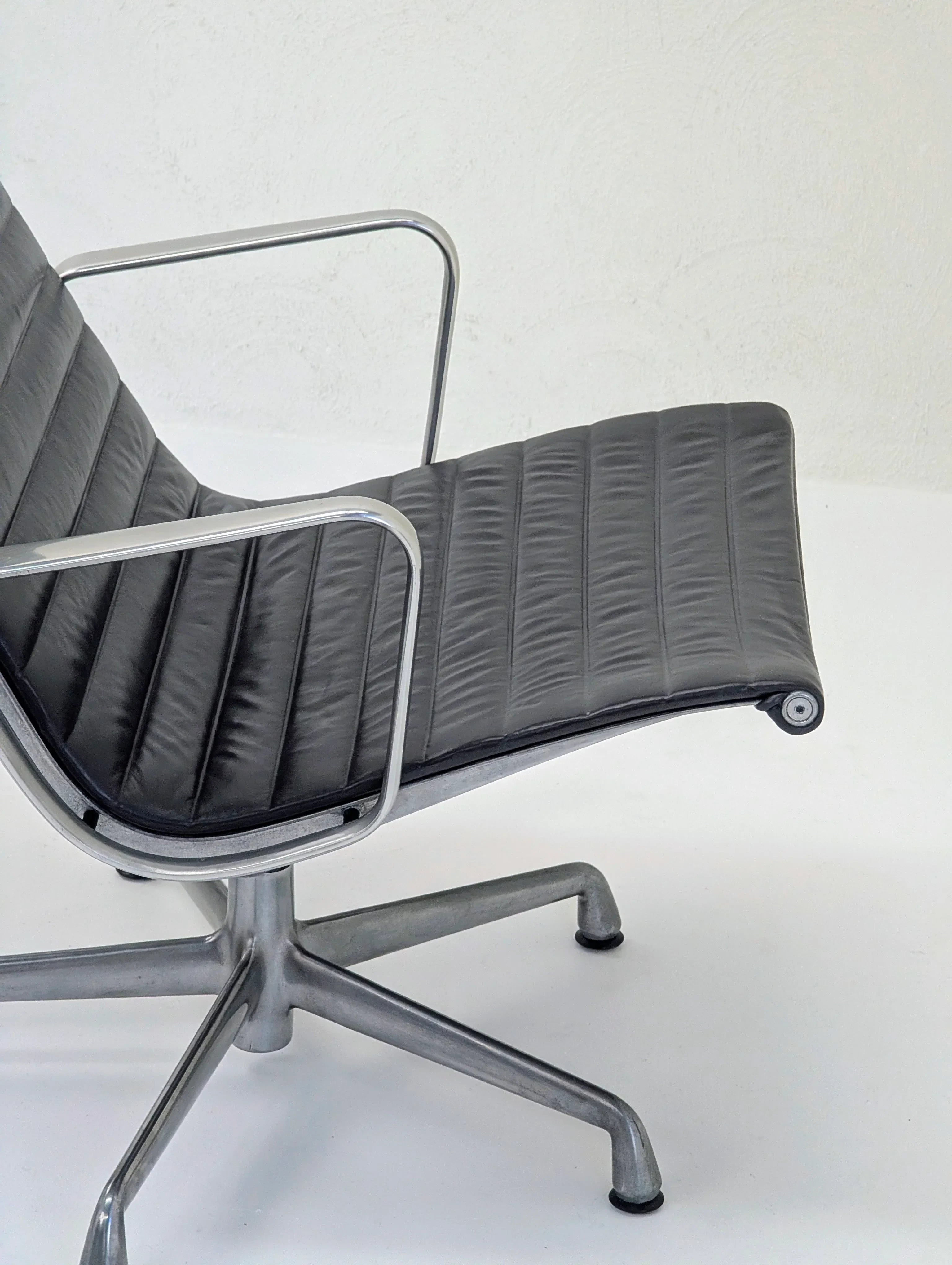 Modern black leather office chair with metal frame on white background