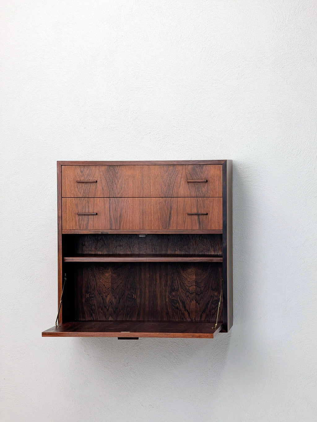Mid-century modern wall-mounted rosewood cabinet with open drop-down desk and drawers