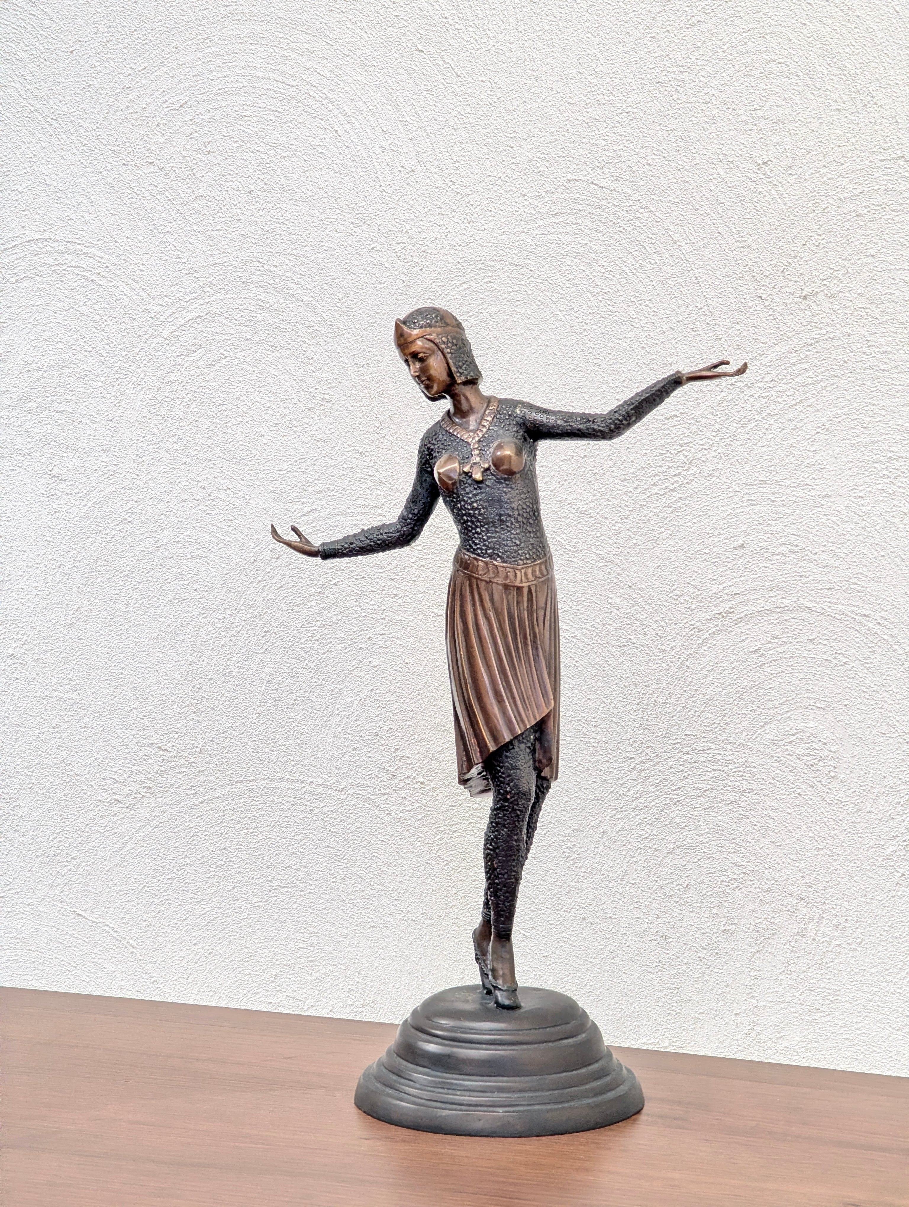 Bronze statue of a woman in a dance pose wearing a textured top, skirt, and heeled shoes on a black circular base