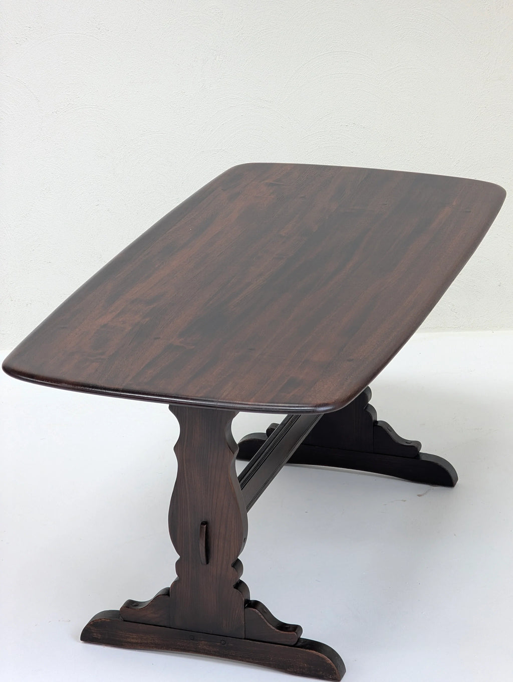 Dark brown wooden rectangular table with curved carved legs on white background