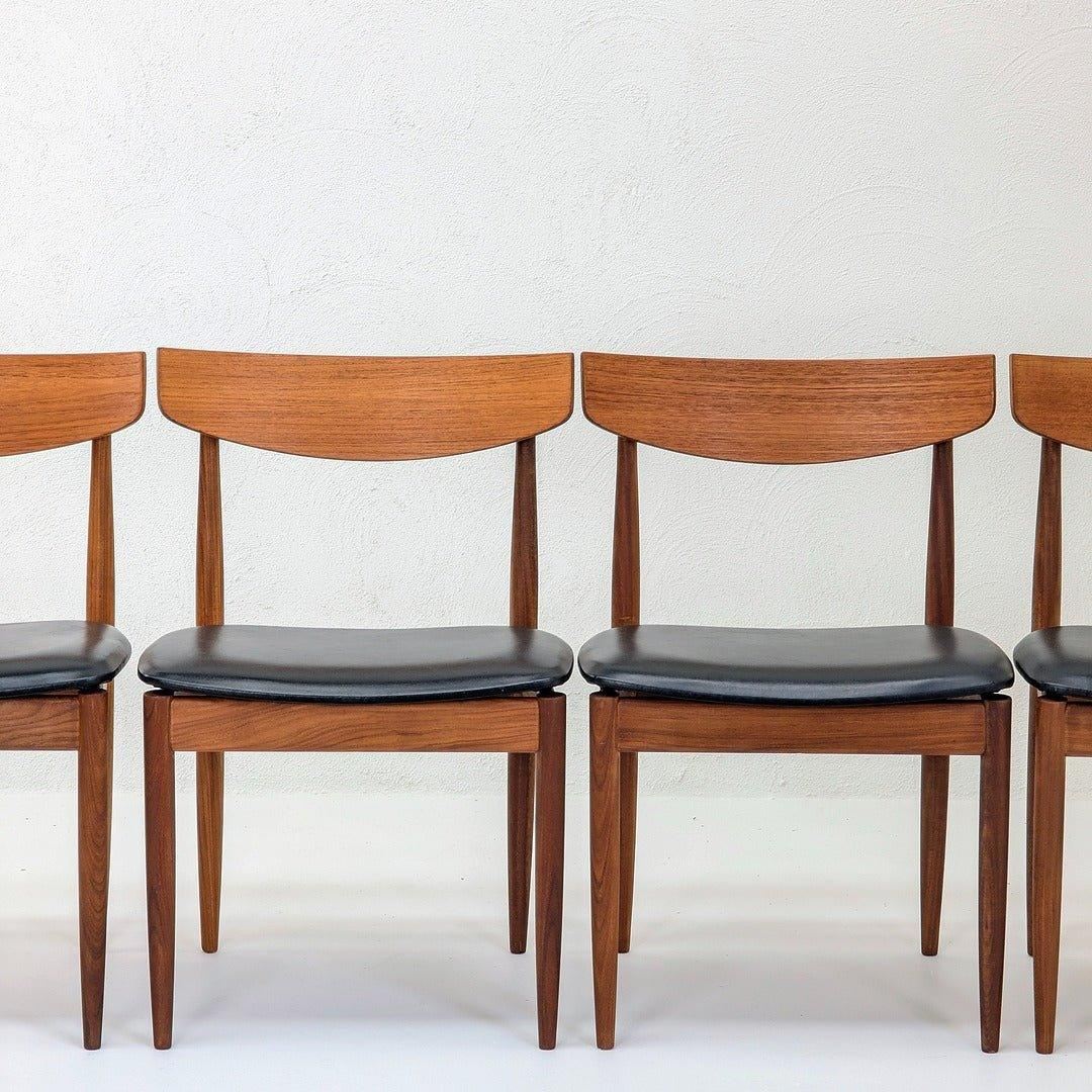 Set of four teak dining chairs with black seats by IB Kofod Larsen for G Plan, mid-century modern style