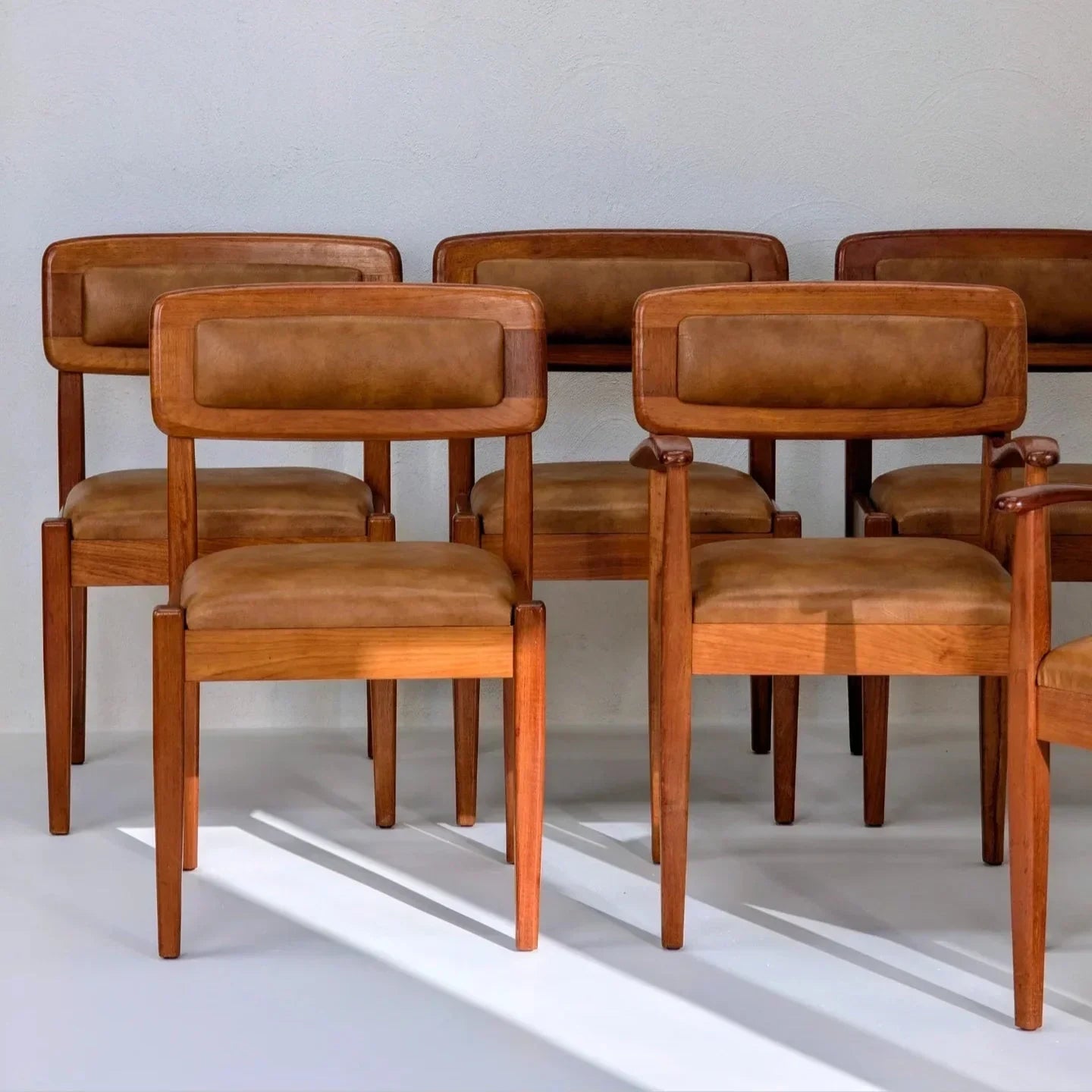 Set of six Blackwood toffee leather dining chairs by Simmons Furniture against white wall
