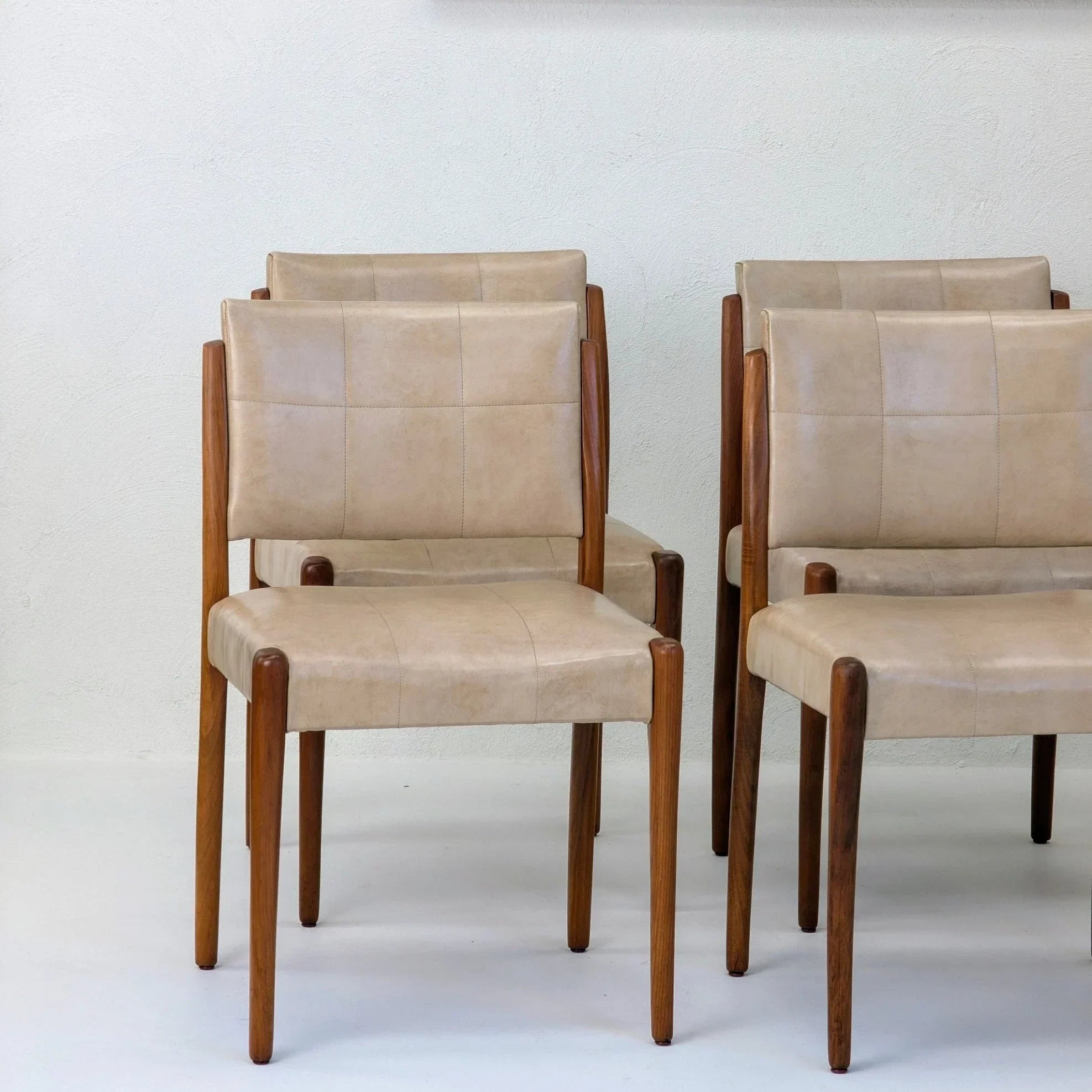 Set of six Fler dining chairs in light tan upholstery with blackwood frames