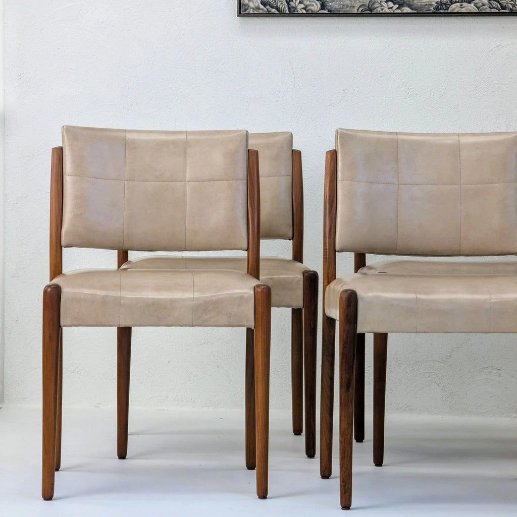 Set of six Fler dining chairs in Blackwood with beige leather upholstery against white wall