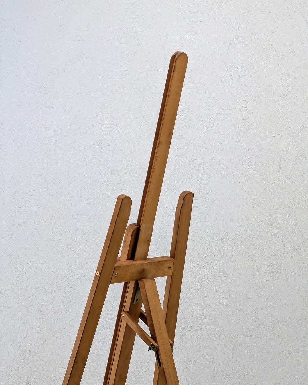 Wooden studio easel by Mabef Italy against a textured white wall