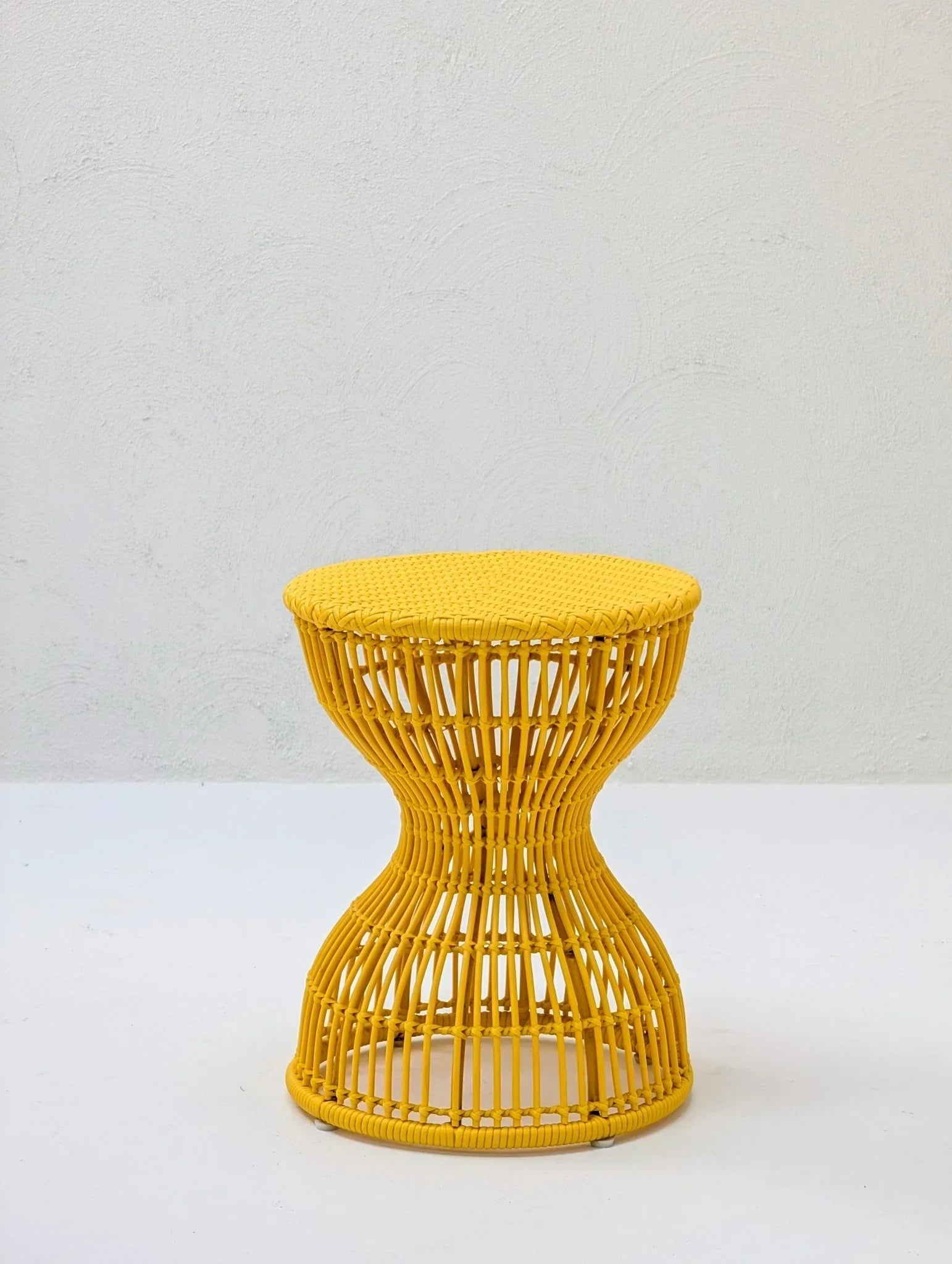 Yellow sculptural woven stool side table with hourglass design on white background