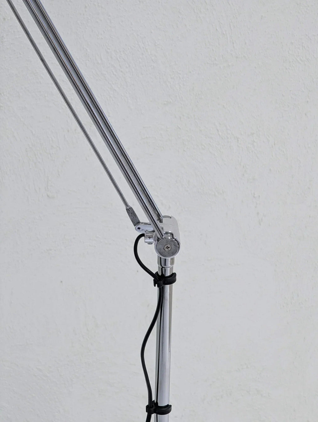 Vintage IKEA Antifoni floor lamp chrome arm with black cord against white wall