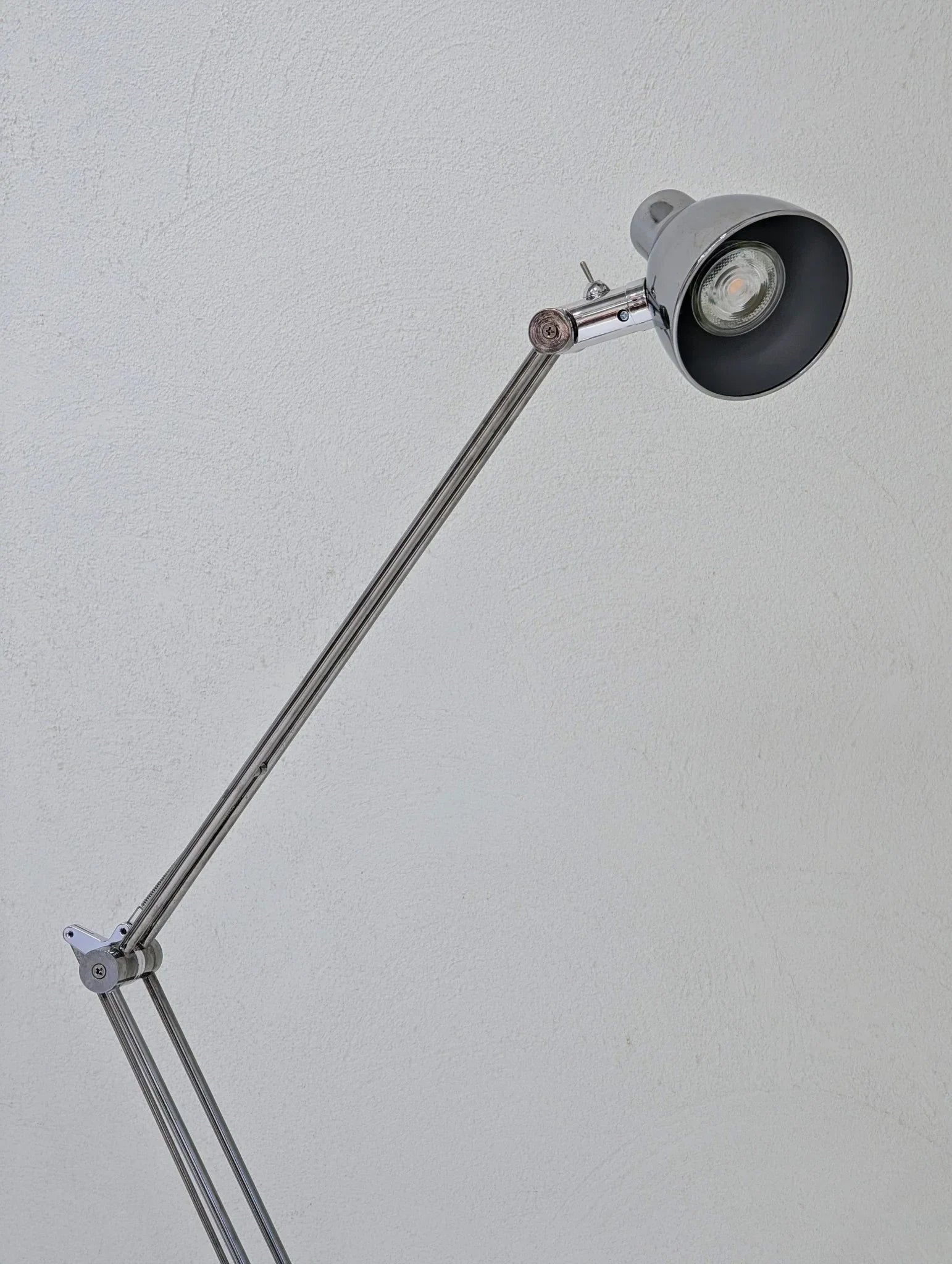 Vintage IKEA Antifoni floor lamp with adjustable chrome arm against white wall