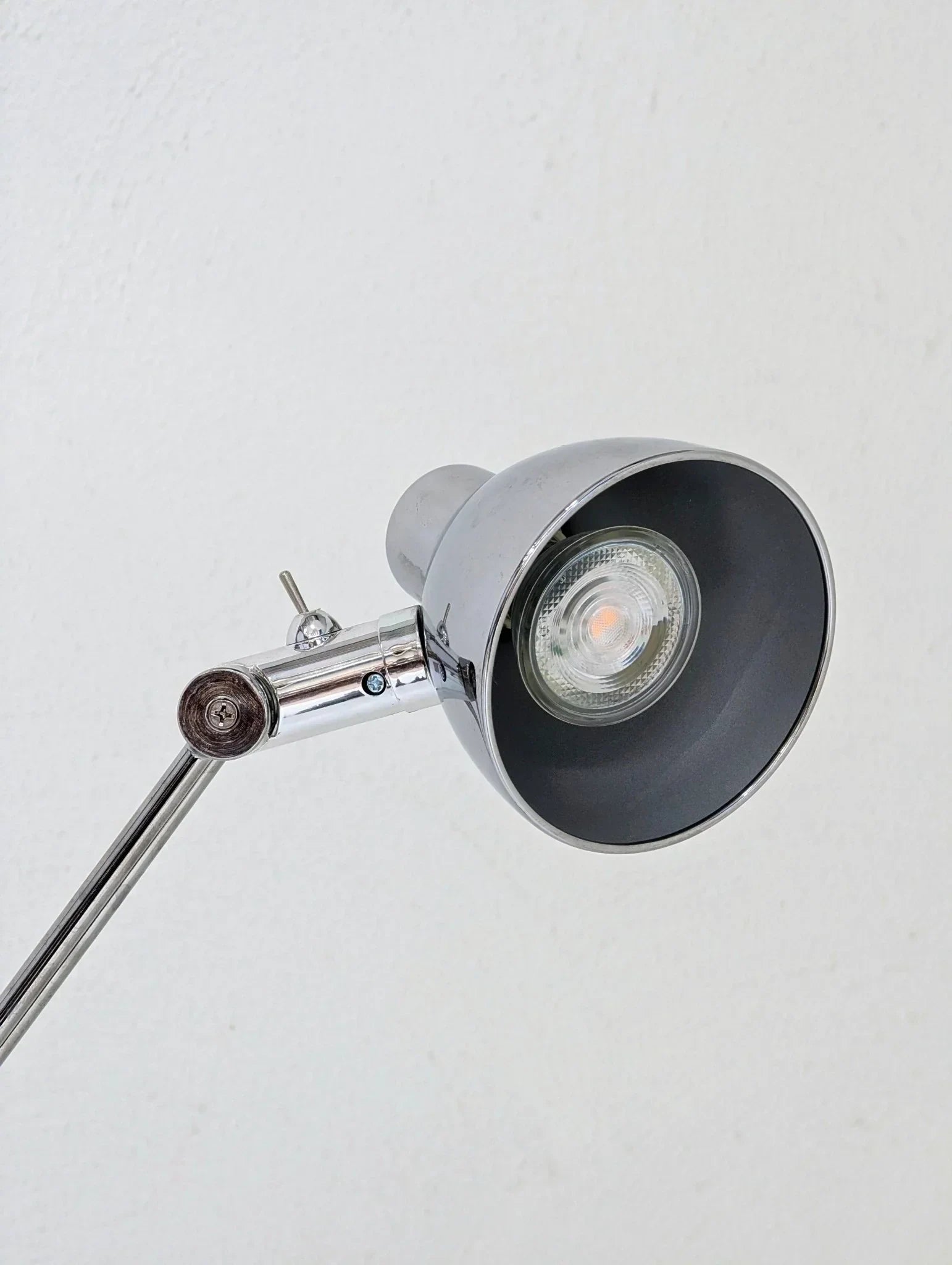 Vintage IKEA Antifoni chrome floor lamp with adjustable arm against a white wall