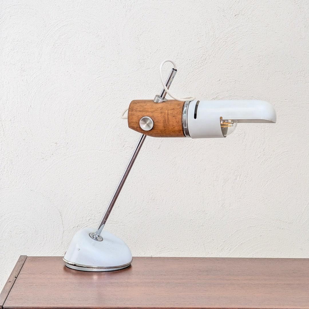 Vintage torpedo table lamp with wood and metal accents on a wooden surface